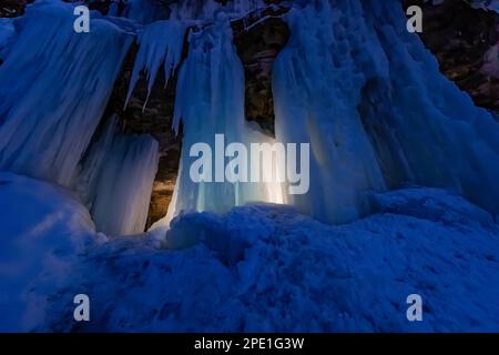 Formation de glace de rideaux illuminée la nuit dans Pictured Rocks National Lakeshore près de Munising, Upper Peninsula, Michigan, États-Unis Banque D'Images