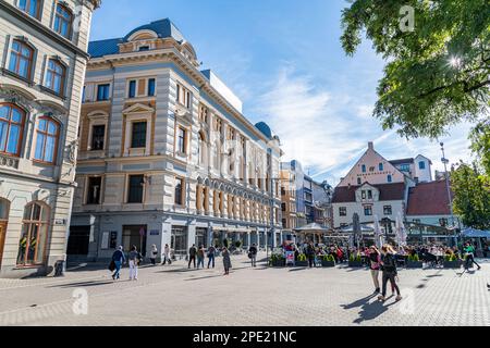 Les gens assis à l'extérieur d'un café/restaurant à la place Livu à Riga, en Lettonie Banque D'Images