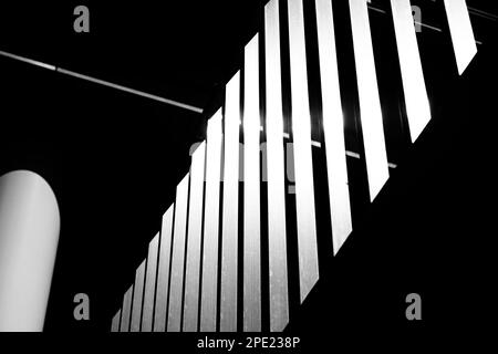 Photo à angle bas d'une rangée de poteaux lumineux lumineux dans un cadre sombre d'un bâtiment Banque D'Images