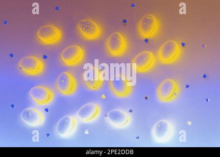 Carte de Pâques abstraite. Œufs lumineux de couleur jaune sur fond bleu. Coeurs brillants. Idéal pour les thèmes de Pâques et de printemps, utilisation dans les matériaux de marketing, l'emballage. Joyeuses vacances Banque D'Images