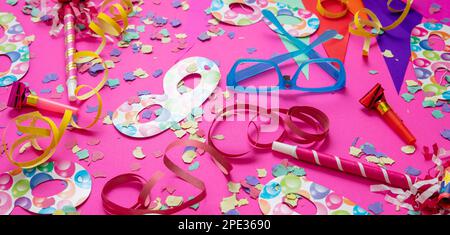 Fête d'anniversaire de carnaval. Confettis et serpentins sur fond rose vif. Fête et décoration Banque D'Images