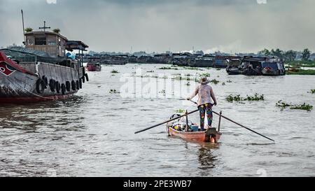 Une femme se tient pour lapider sa stalle de nouilles dans une communauté vivant sur des bateaux sur le Mékong, près de long Xuyen dans le delta du Mékong, au Vietnam. Banque D'Images