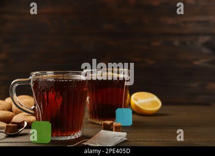 Sachets de thé dans des tasses en verre d'eau chaude et de cubes de sucre Banque D'Images