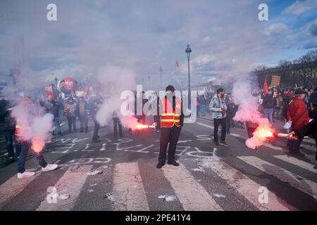 Paris, FRANCE. 15th mars 2023. Les membres du syndicat communiste, la CGT, utilisent des fusées alors que dix des milliers de personnes marchent dans le centre de Paris contre les plans de réforme des retraites. Les projets du gouvernement Emmanuel Macron, visant à faire passer l'âge de la retraite de 62 à 64 ans, ont été heurtés à une colère et à des protestations. Crédit : ZUMA Press, Inc./Alay Live News Banque D'Images