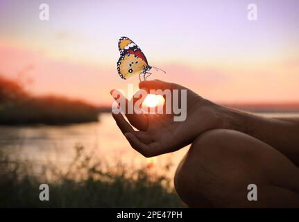 Homme méditant près de la rivière au coucher du soleil, à proximité. Espace pour le texte Banque D'Images