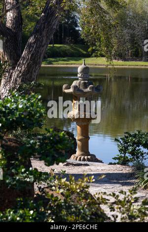 Lanterne de roche au bord d'un lac au Musée Morikami et jardin japonais, Delray Beach, Floride, États-Unis Banque D'Images