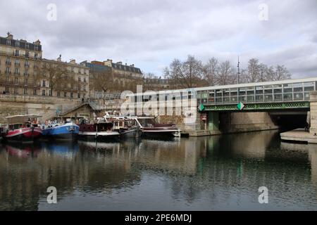 Vue sur un pont au-dessus du Canal Saint Martin une voie navigable parisienne qui mène directement à la Seine située à Paris France. Banque D'Images