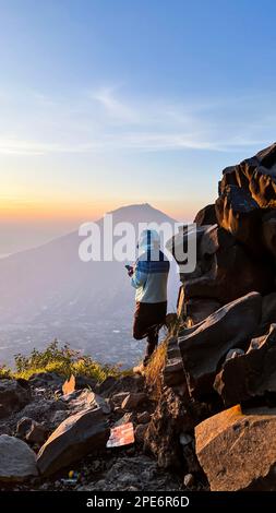 L'homme salue le lever du soleil dans les montagnes. Un homme salue l'aube. Java Ouest, Indonésie, 16 mars 2023 Banque D'Images