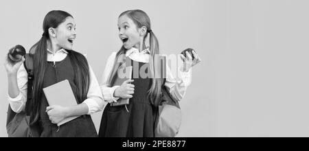 Filles d'école amis. Les enfants surpris tiennent des pommes. . Affiche horizontale isolée de la jeune fille étudiante. Bannière en-tête portrait de la copie de fille d'école Banque D'Images