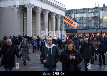 Un partisan du président russe Vladimir Poutine porte un drapeau sur la place Komsomolskaya. Le drapeau porte un portrait de Poutine. Le texte sur le drapeau dit: «Pour la mère patrie! Pour la souveraineté! Pour Poutine!". Banque D'Images