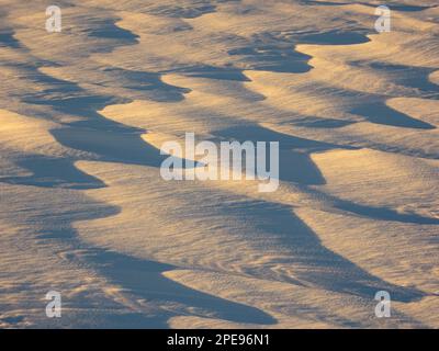 La lumière du coucher du soleil met en lumière les motifs de neige pétoncle sur le lac du centre-sud de l'Alaska. Banque D'Images