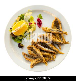 Anchois frits avec garniture de légumes et citron frais Banque D'Images