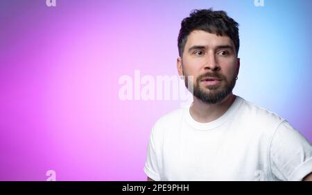 Un beau pensif barbu avec des boucles d'oreilles avec un look anxieux et confus décisionnaire sur un fond juteux dégradé. Anxiété et inquiétude Banque D'Images