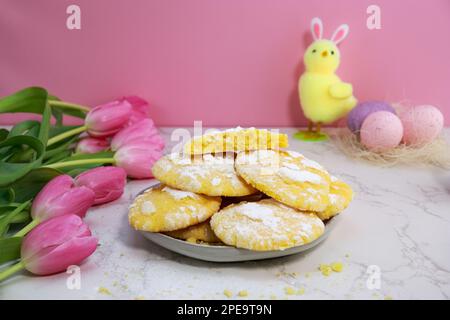 gros plan de biscuits craquelés au citron sur l'assiette, pâques. thème avec œufs et tulipes Banque D'Images