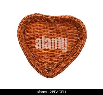 Panier en osier isolé en forme de coeur. Panier tissé vide en forme de coeur isolé sur fond shite. Banque D'Images