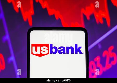 Sur cette photo, les États-Unis Logo Bancorp (US Bank) affiché sur un écran de smartphone, avec représentation graphique du marché boursier en arrière-plan. Banque D'Images