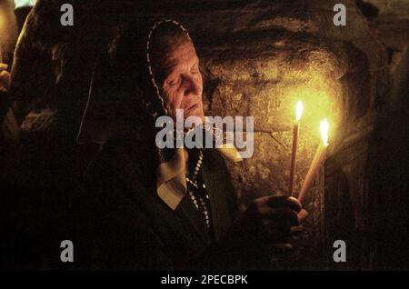 Comté de Hunedoara, Roumanie, 2002. Croyants aux bougies allumées pendant le service religieux de l'église chrétienne orthodoxe Densus. Banque D'Images