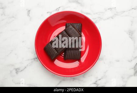 Assiette rouge avec hématogène délicieux et sain sur une table en marbre, vue du dessus Banque D'Images