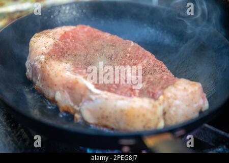 Faire griller un steak de Ribeye dans un wok Banque D'Images