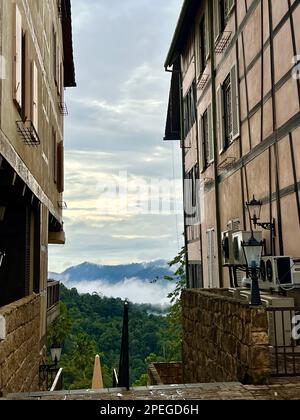 Colmar Tropicale, Malaisie. 02nd mars 2023. A travers deux maisons à colombages, on peut voir des wafts de brume au-dessus de la jungle des collines de Berjaya. Une heure de route au nord-est de la capitale Kuala Lumpur se trouve une réplique de la ville de Colmar, classée au patrimoine mondial, en Alsace. Le clone de la forêt tropicale a été construit en 1990s à la demande de l'ancien chef du gouvernement Mahathir Mohamed et a depuis ravi des visiteurs de près et de loin. (À dpa: Colmar Tropicale: Un morceau d'Alsace dans la jungle de la Malaisie) Credit: Carola Frentzen/dpa/Alay Live News Banque D'Images