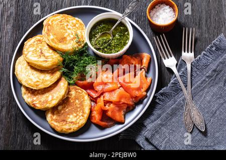 petit-déjeuner crêpes de levure avec gravelax maison de saumon avec sauce à l'aneth pesto sur l'assiette sur table en bois sombre Banque D'Images
