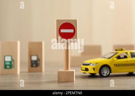 Panneau de signalisation pas d'entrée et voiture de taxi jouet sur table en bois. Réussite à l'examen du permis de conduire Banque D'Images