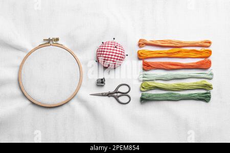 Composition Flat Lay avec fils et cerceau brodé sur tissu blanc Banque D'Images