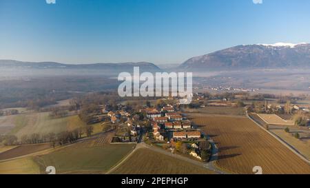 Une vue aérienne d'un paysage rural avec une vallée brumeuse et une petite ville à proximité Banque D'Images