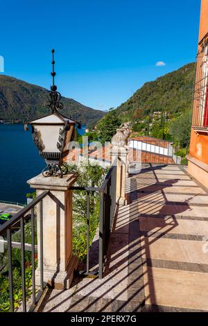 Balcon avec vue sur le lac de Lugano avec montagne et ciel bleu clair de Morcote, Tessin, Suisse. Banque D'Images