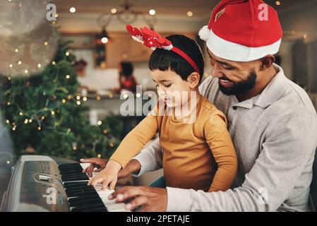 Joyeux père, enfant et piano pour la fête de noël, chants et hymne de Noël à la maison. Instrument de clavier pour parents, garçons et enfants, musique festive Banque D'Images