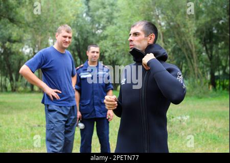 Service de secours, grenouille. Un maître-nageur mettant la combinaison, d'autres regardant. 10 août 2018 Kiev Ukraine Banque D'Images