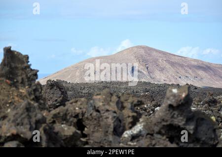 Vue sur les formations rocheuses volcaniques de la bombe volcanique et les champs de lave jusqu'aux volcans lointains parque nacional de timanfaya Lanzarote, îles Canaries, Spa Banque D'Images