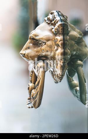 Un porte-lion en laiton sur une porte dans l'une des rues arrière de Venise, Italie. Banque D'Images