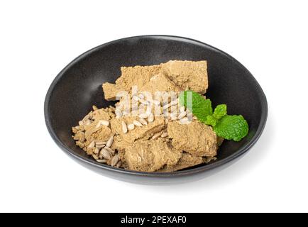 Morceaux de halva dans Black Bowl isolé, Sunflower Halawa, halvah ou Halwa sur fond blanc Banque D'Images