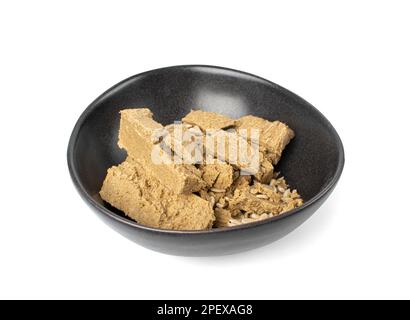 Morceaux de halva dans Black Bowl isolé, Sunflower Halawa, halvah ou Halwa sur fond blanc, Clipping Path Banque D'Images