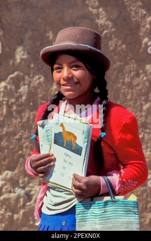 Bolivie, Potosi. Portrait d'une fille avec ses livres scolaires. Banque D'Images