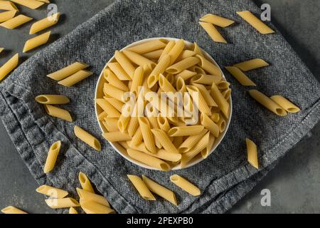 Séchez les pâtes de Penne biologiques dans un bol Banque D'Images