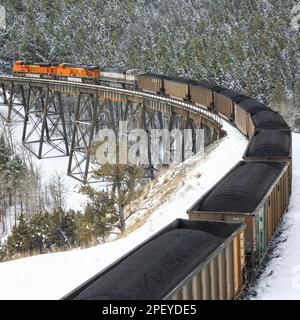 en hiver, prenez un train transportant du charbon au-dessus du tréteau sous le col de mullan près d'austin, montana Banque D'Images