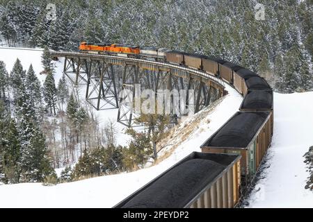 en hiver, prenez un train transportant du charbon au-dessus du tréteau sous le col de mullan près d'austin, montana Banque D'Images