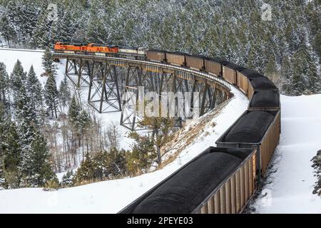 en hiver, prenez un train transportant du charbon au-dessus du tréteau sous le col de mullan près d'austin, montana Banque D'Images