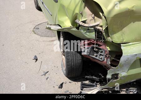 Pare-chocs de voiture bosselé et feu arrière. Le transport s'est écrasé metall sur une voiture privée. Concept d'assurance automobile. Vert métallisé Banque D'Images