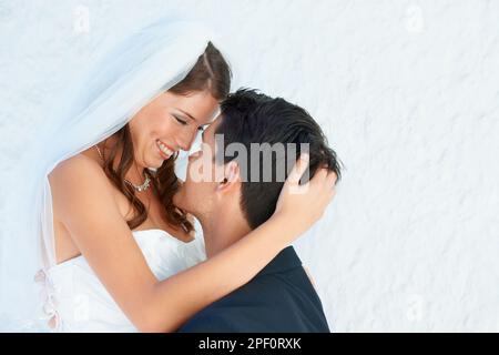 Voler un moment loin de la foule. Un marié soulevant sa belle mariée dans l'air et souriant à elle. Banque D'Images