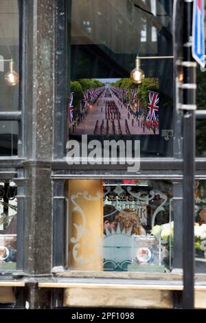 Un écran de télévision affiche la couverture funèbre de feu la reine Elizabeth II dans un pub du centre de Londres, le jour de ses funérailles. Banque D'Images