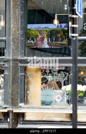 Un écran de télévision affiche la couverture funèbre de feu la reine Elizabeth II dans un pub du centre de Londres, le jour de ses funérailles. Banque D'Images