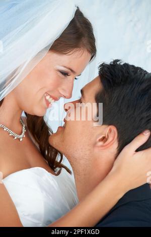 Le romantisme de leur époque. Un marié soulevant sa belle mariée dans l'air et souriant à elle. Banque D'Images