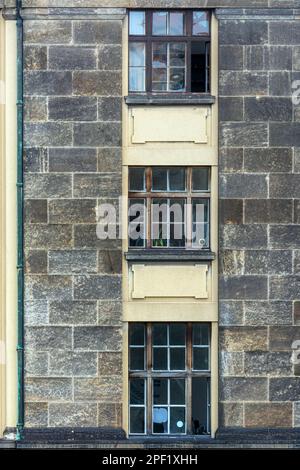 Trois fenêtres rectangulaires situées verticalement l'une au-dessus de l'autre sur la façade d'un bâtiment en pierres grises. De la Windows du monde ser Banque D'Images