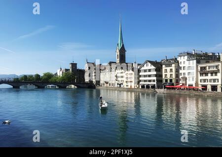 Zurich, Suisse, 25 juillet: Deux personnes dans un bateau flottent sur le Limmat avec l'église Fraumunster en arrière-plan, le jour d'été ensoleillé, juillet Banque D'Images