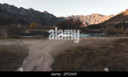 Une vieille marque de voitures 'Honda HR-V' se trouve à la distance de la route sous les montagnes près de la rivière Katun en Altai en Sibérie dans la soirée. Altaï, R Banque D'Images