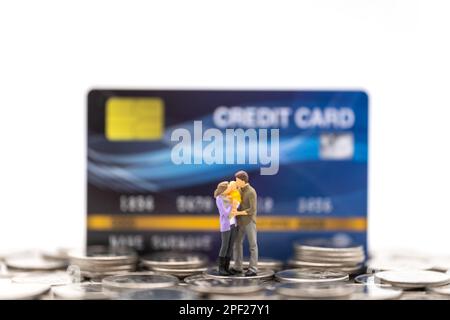 Concept argent, financier, paiement, entreprise et famille. Parent et enfant figurines miniatures homme, femme debout sur pile de pièces avec FAUSSE maquette crédit Banque D'Images