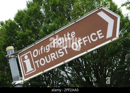 Panneau routier bilingue pointant vers l'office du tourisme à Adare, comté de Kerry Irlande Banque D'Images